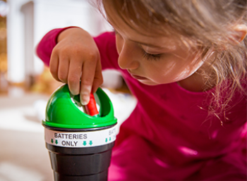 child recycling a battery