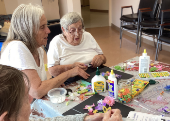 Seniors sitting at a table making art.