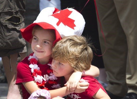 Two children dressed in Canada Day clothing at a parade