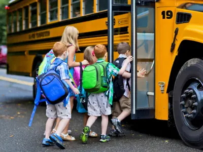 kids getting onto a school bus