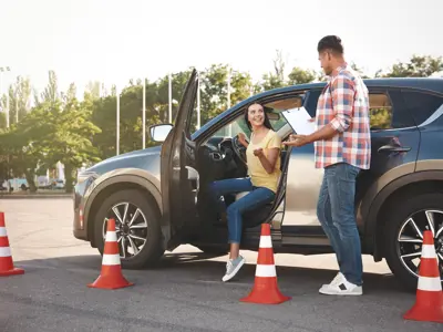 driving school instructor and student getting out of a car