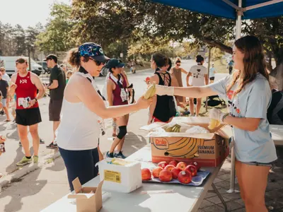Volunteer handing a banana to a participant at a rest stop