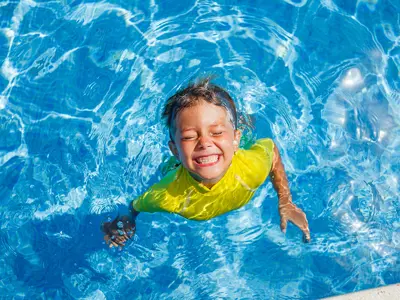 camper swimming with big smile