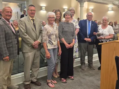 Photo of a group of people posed as one holds an award.