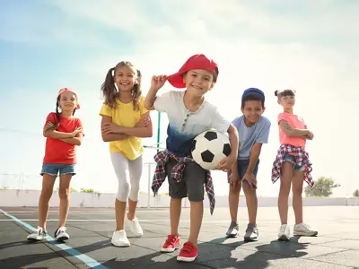 kids playing socccer and posing for a picture