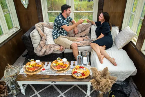 man and woamn eating on outdoor couch