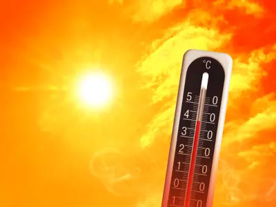 a temperature gauge showing the heat against a yellow-tinted sky with the sun