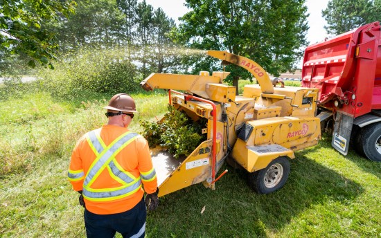Crews cleaning up brush with a woodchipper