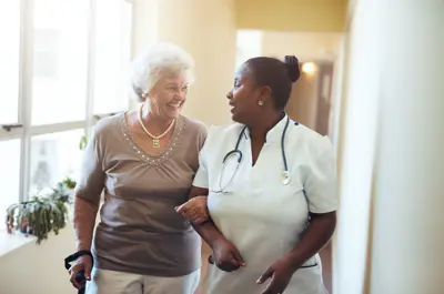 Senior woman walking with nurse