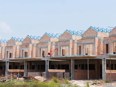 Row of unfinished houses under construction against a blue sky