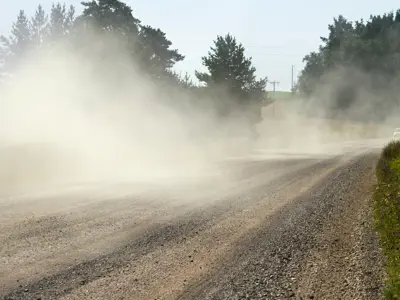 dust on the road after a car has driven by