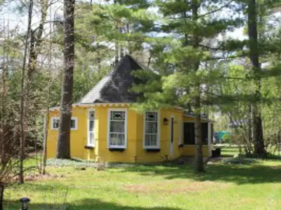 Small historic wooden cottage surrounded by trees