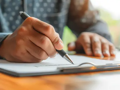 A person's hands signing a contract