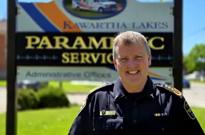Man in uniform standing in front of Paramedic Services sign outside