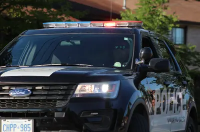 Cropped view of police car with lights on and an officer in the driver's seat