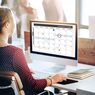 person checking their calendar on a computer
