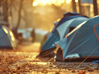 Tents in a row on a path with trees in the background