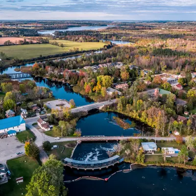 Aerial view of river with multiple bridges overtop and town buildings and houses surrounding the town