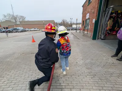 Firefighter Showing Georgia How To Use A Fire Hose