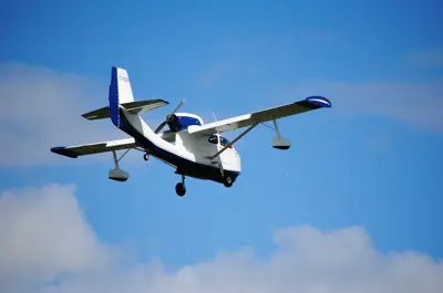 Small plane in a blue sky with some clouds