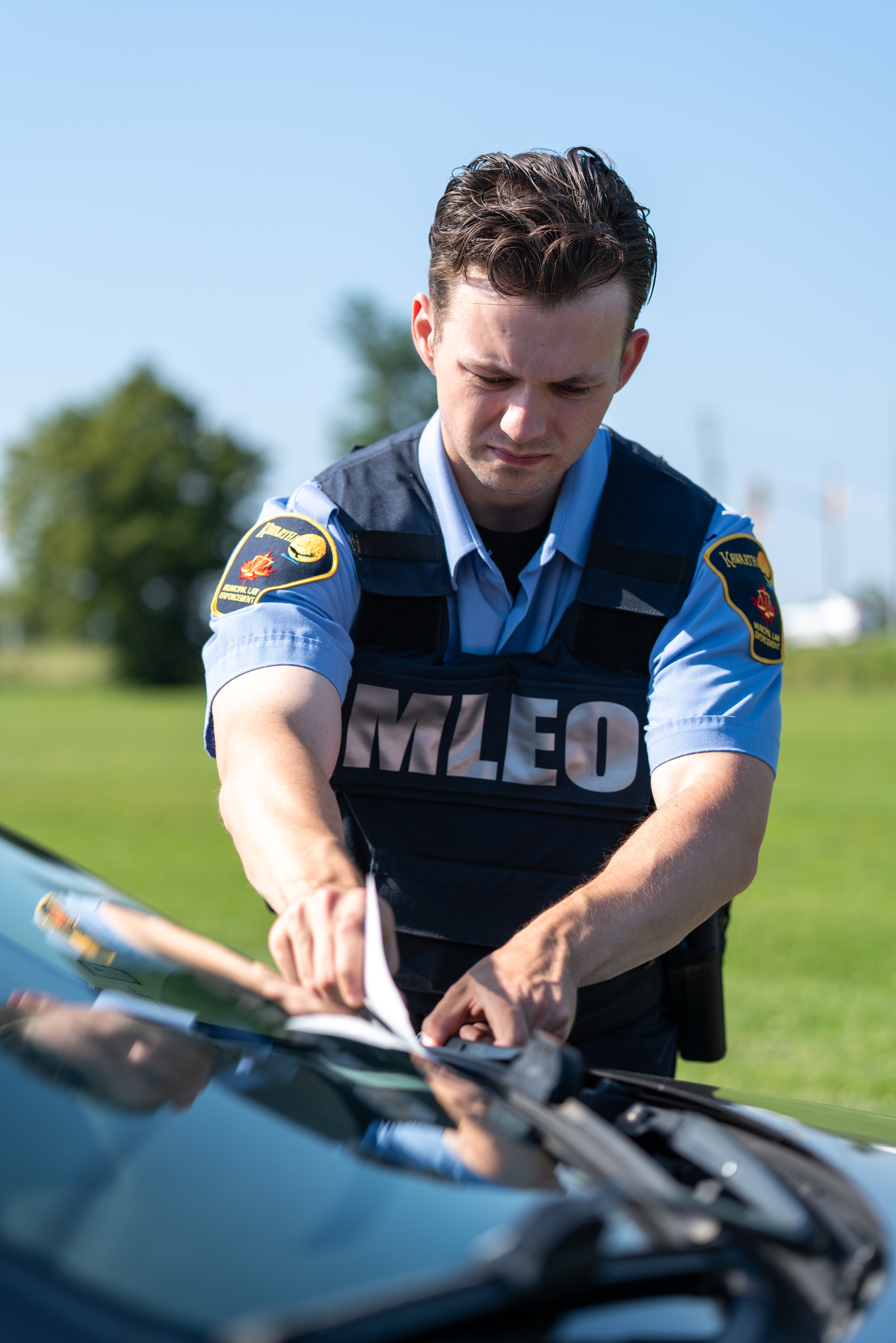 bylaw officer giving a parking ticket