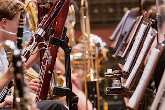 Close up photo of young people playing woodwind instruments.