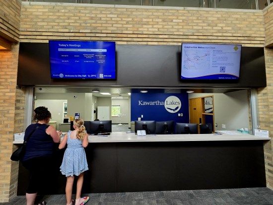 A mother and daughter at the Lindsay Municipal Service Centre desk