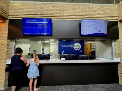 A mother and daughter at the Lindsay Municipal Service Centre desk