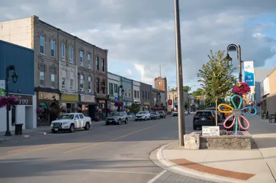 Road with curb and sidewalk, buildings and cars parked on road