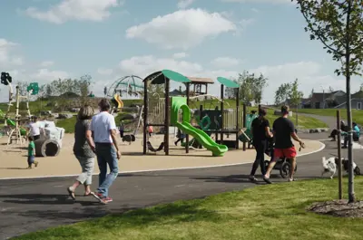 Park playground with people walking on walkway