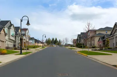 Street with paved road and row of houses on either side.
