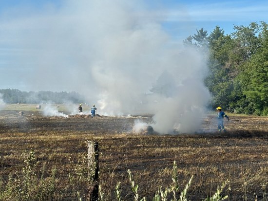 Firefighters putting out a fire in a farmer's field