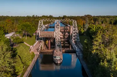 A river with trees on both sides. A lock is situated on top of the river.