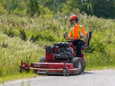 Parks student cutting grass in a municipal park.