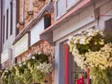 View of store fronts in a row with hanging flowers in front