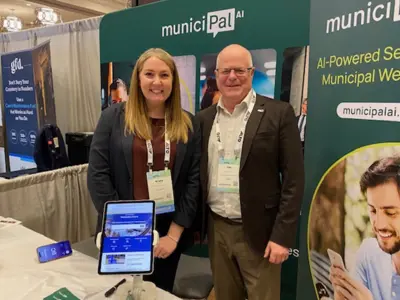 Photo of a smiling woman and man standing in front of a commercial display.