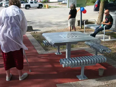 Game board picnic table with a woman walking nearby
