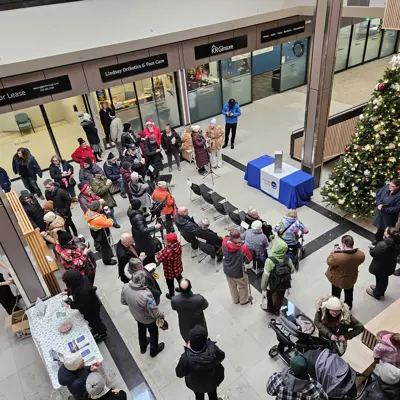 Photo of a crowd of peple gathered around a table, viewed from above.
