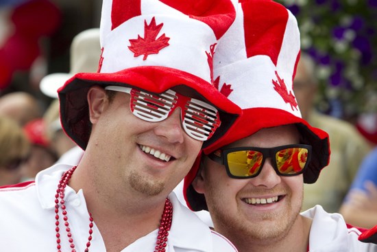 Two friends in Canada Day hats and sunglasses enjoying the Bobcaygeon Canada Day parade