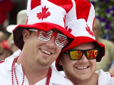 Two friends in Canada Day hats and sunglasses enjoying the Bobcaygeon Canada Day parade