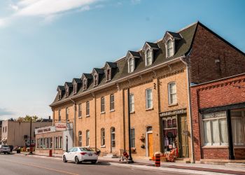 Historic red-brick building with a car parked in front.