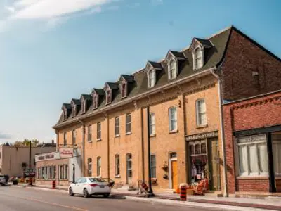 Historic red-brick building with a car parked in front.